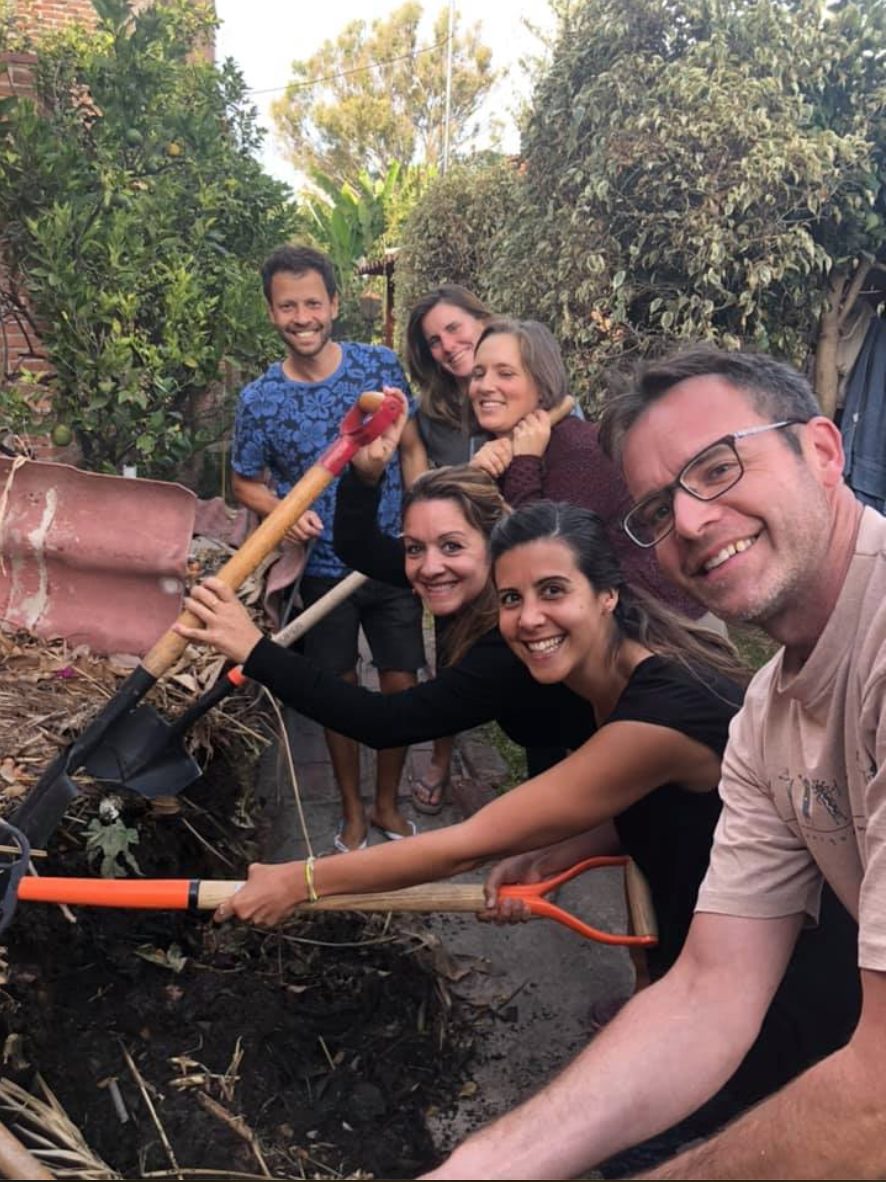 Group of people planting a garden together outdoors.