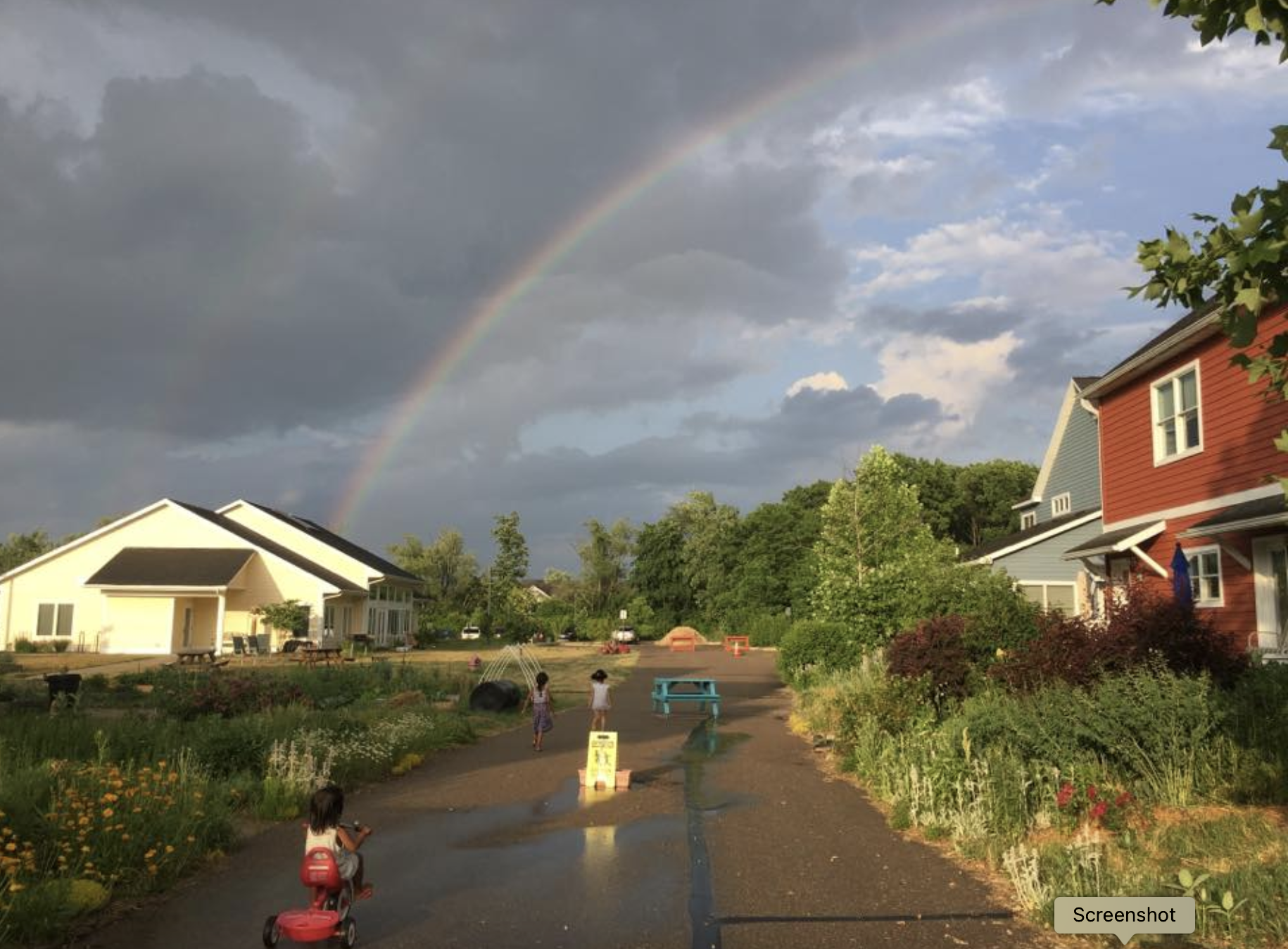Rainbow over community homes in a peaceful neighborhood.
