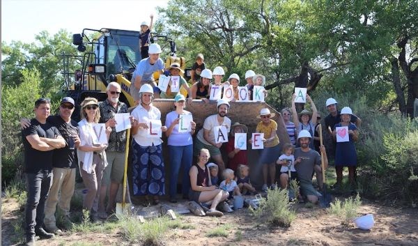 Group of people holding signs at community project site.