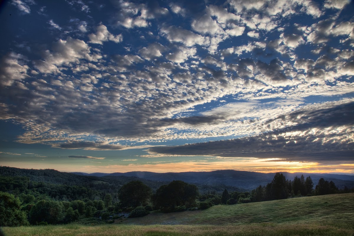 Beautiful landscape view with rolling hills and dramatic sky at sunset.
