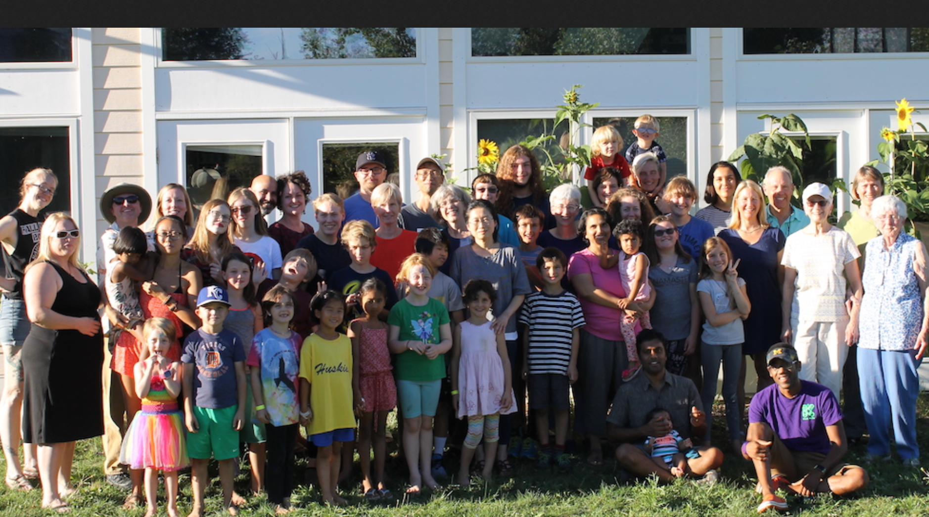 Large diverse group of people gathered outdoors at Touchstone Cohousing community.