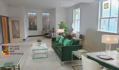 Spacious living room with green sofa, large windows, and modern decor.