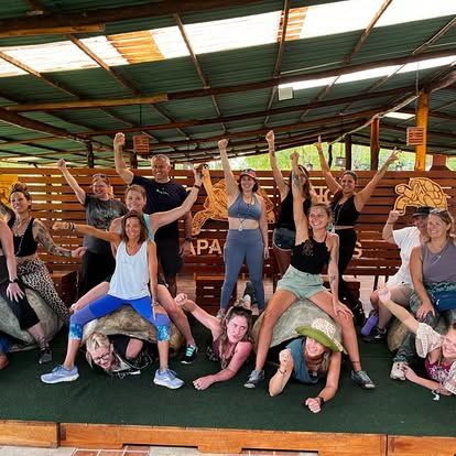 Group of diverse people celebrating at a community event in a rustic outdoor setting.