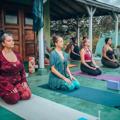 People practicing yoga outdoors at Foundation for Intentional Community.