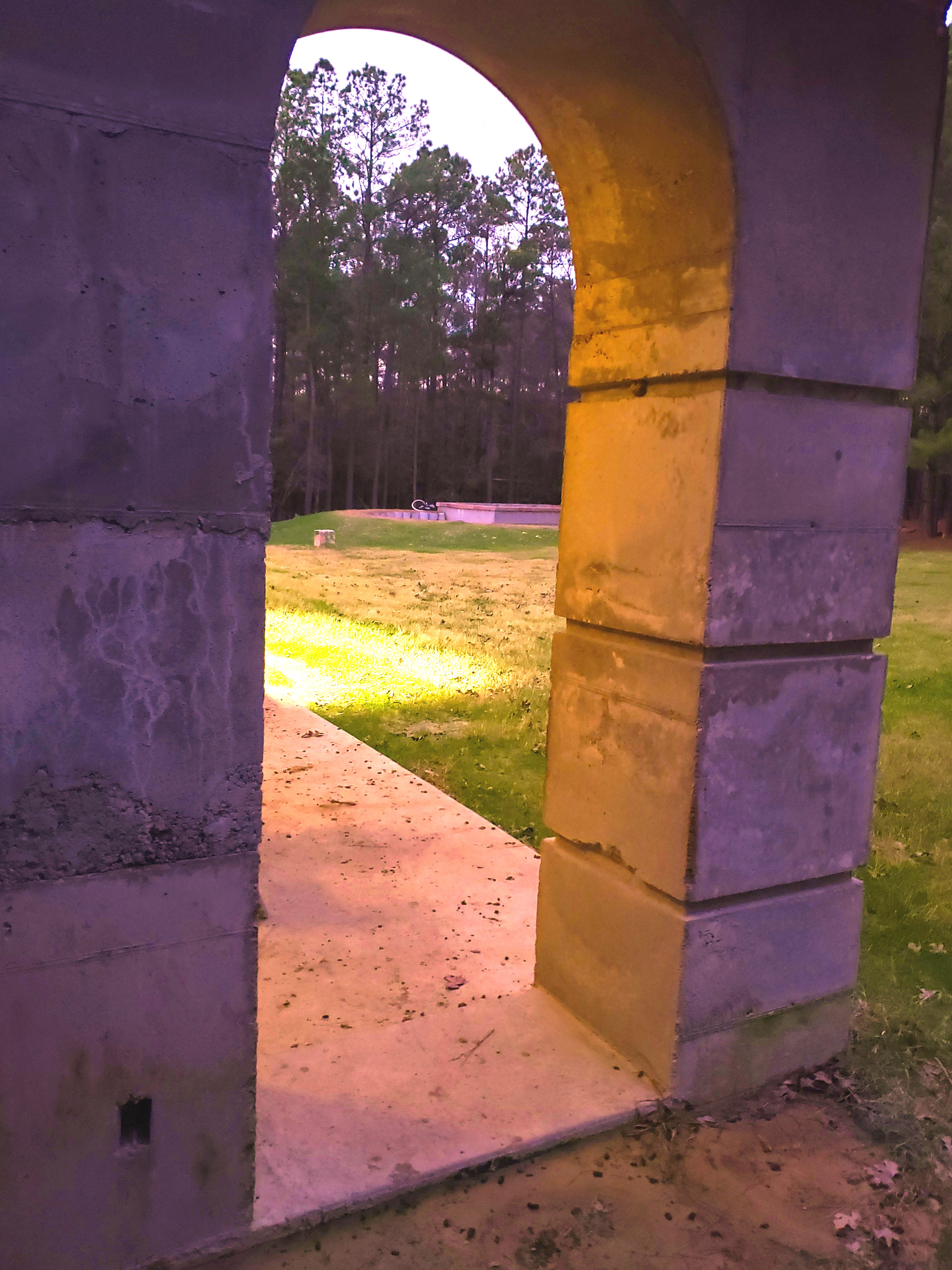 Stone archway at Foundation for Intentional Community with scenic background.