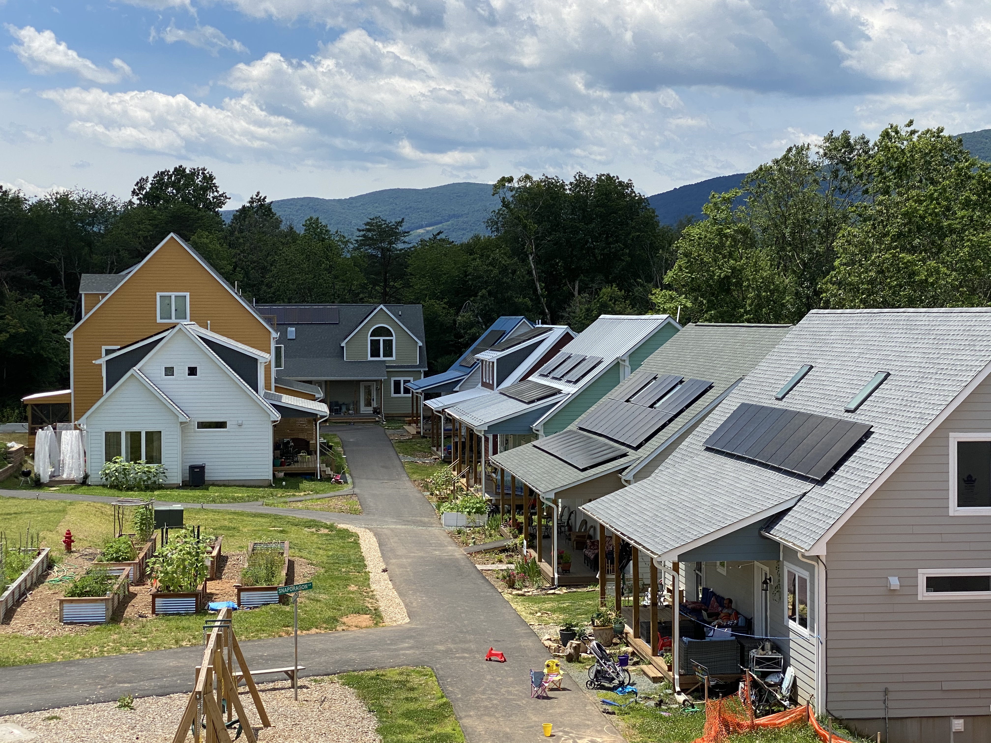 Eco-friendly cohousing neighborhood with solar panels and gardens.
