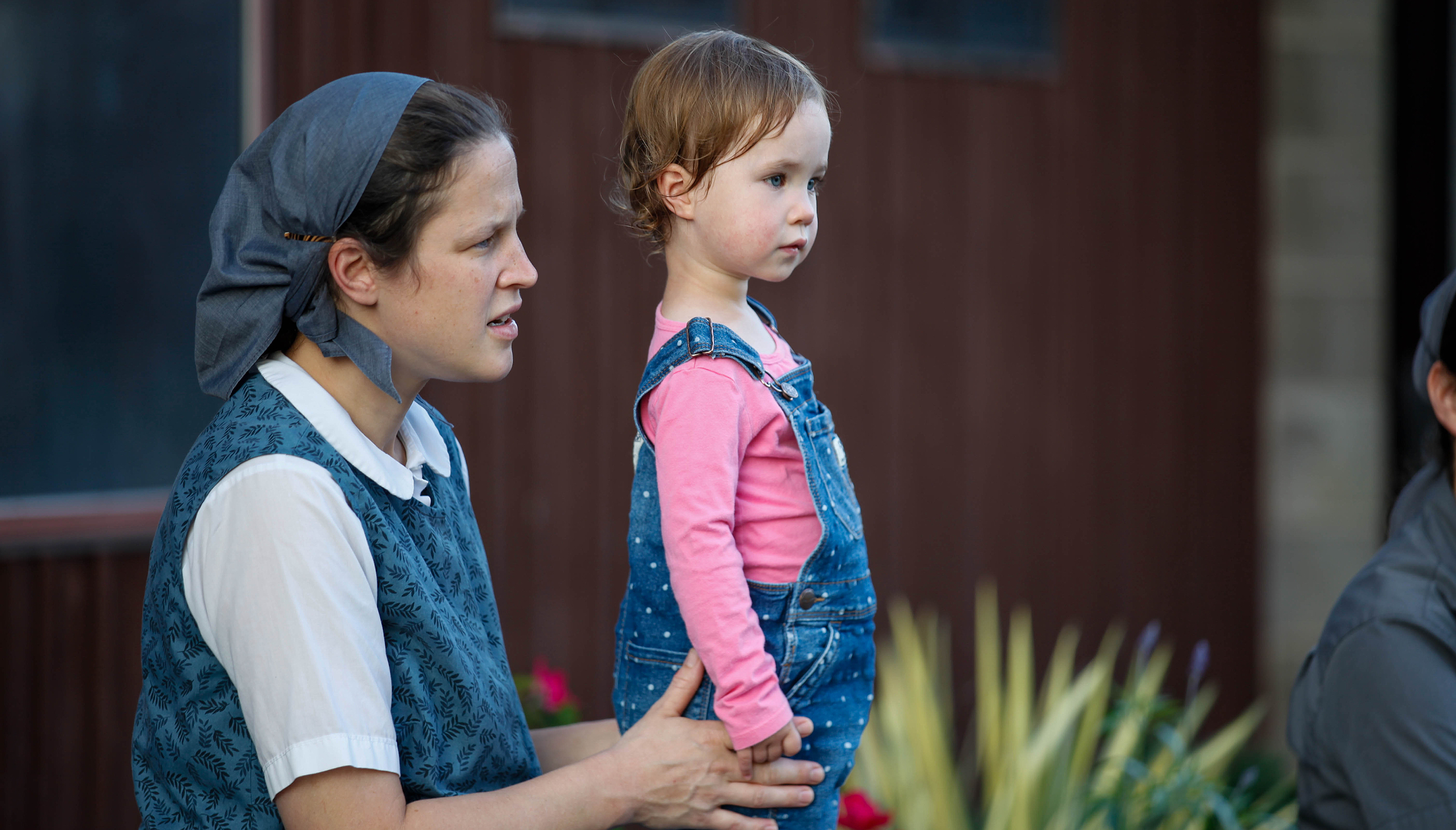 Woman holding a young girl at the Foundation for Intentional Community event.