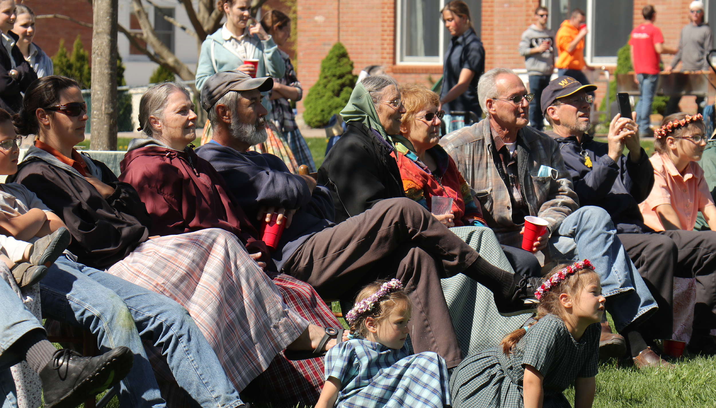 People sitting outdoors at a community event in Bellvale Bruderhof.