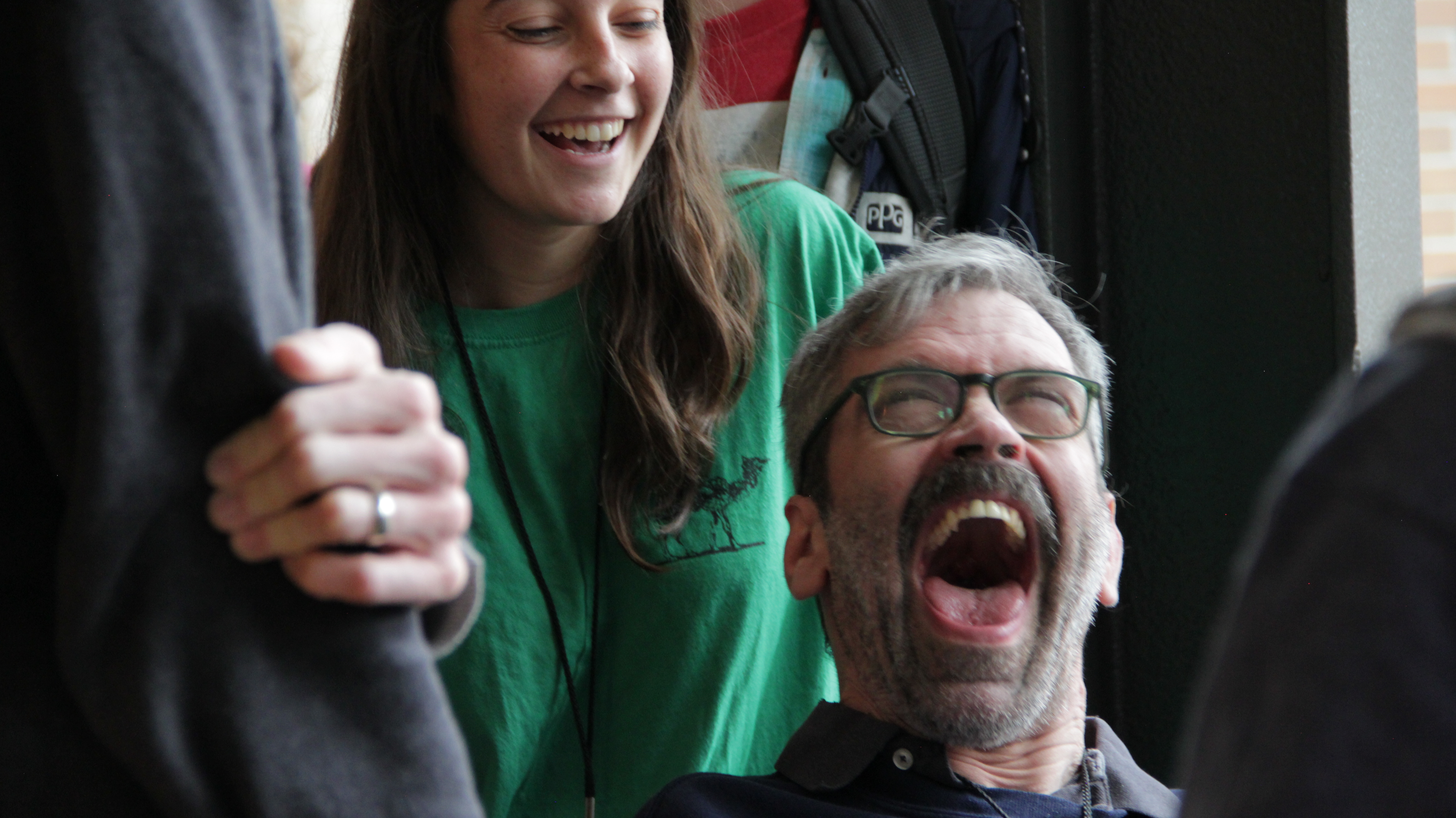 People smiling and laughing at L'Arche Portland community event.