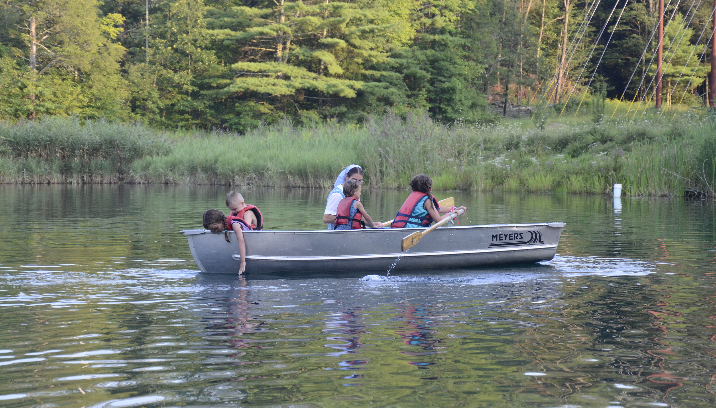 Family enjoying canoe ride on a peaceful lake at Foundation for Intentional Community.