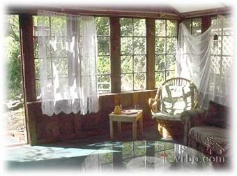 Sunroom with large windows, curtains, and cozy seating at Coho Canyon.