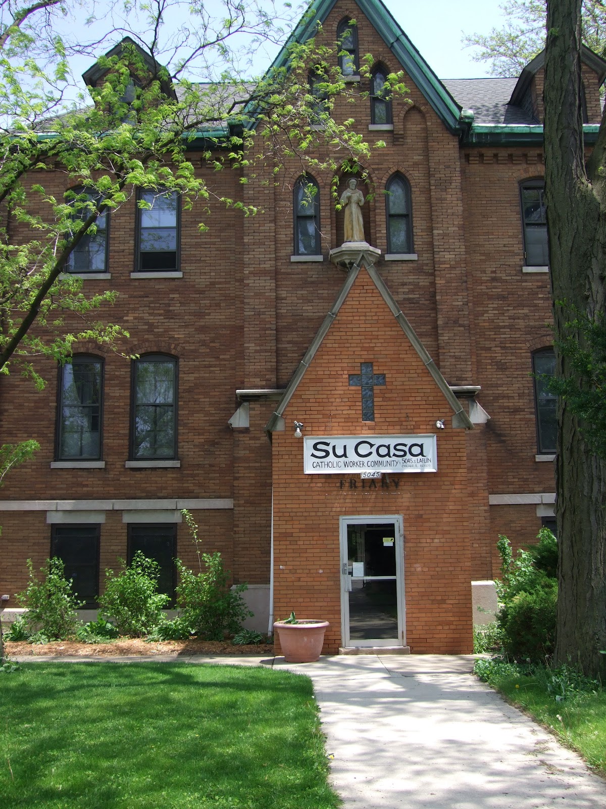 Historic brick church with community center sign and cross.