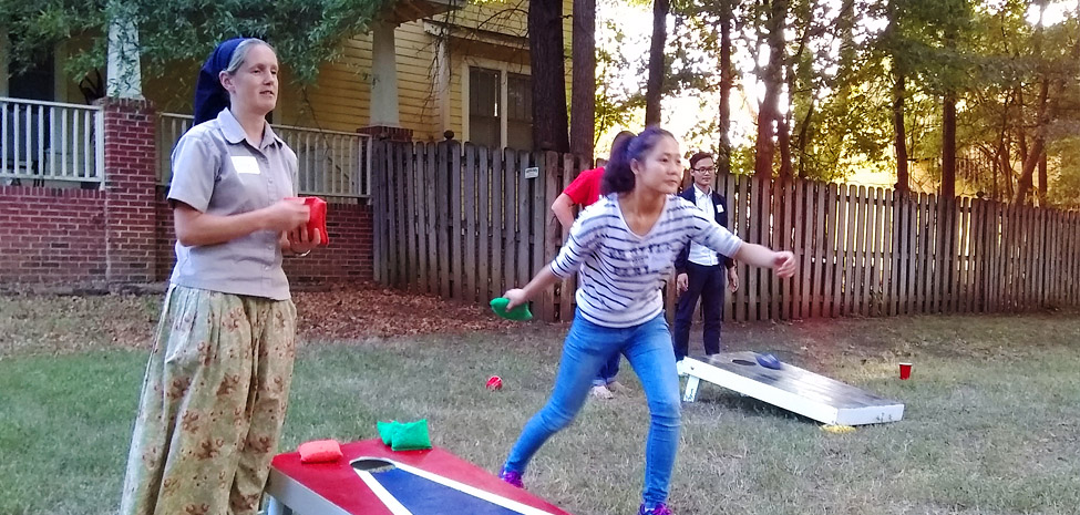 People playing outdoor games at Durham Bruderhof House community event.