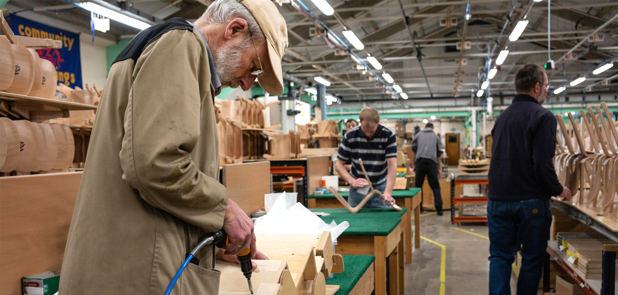 People working on woodworking projects in a community workshop.