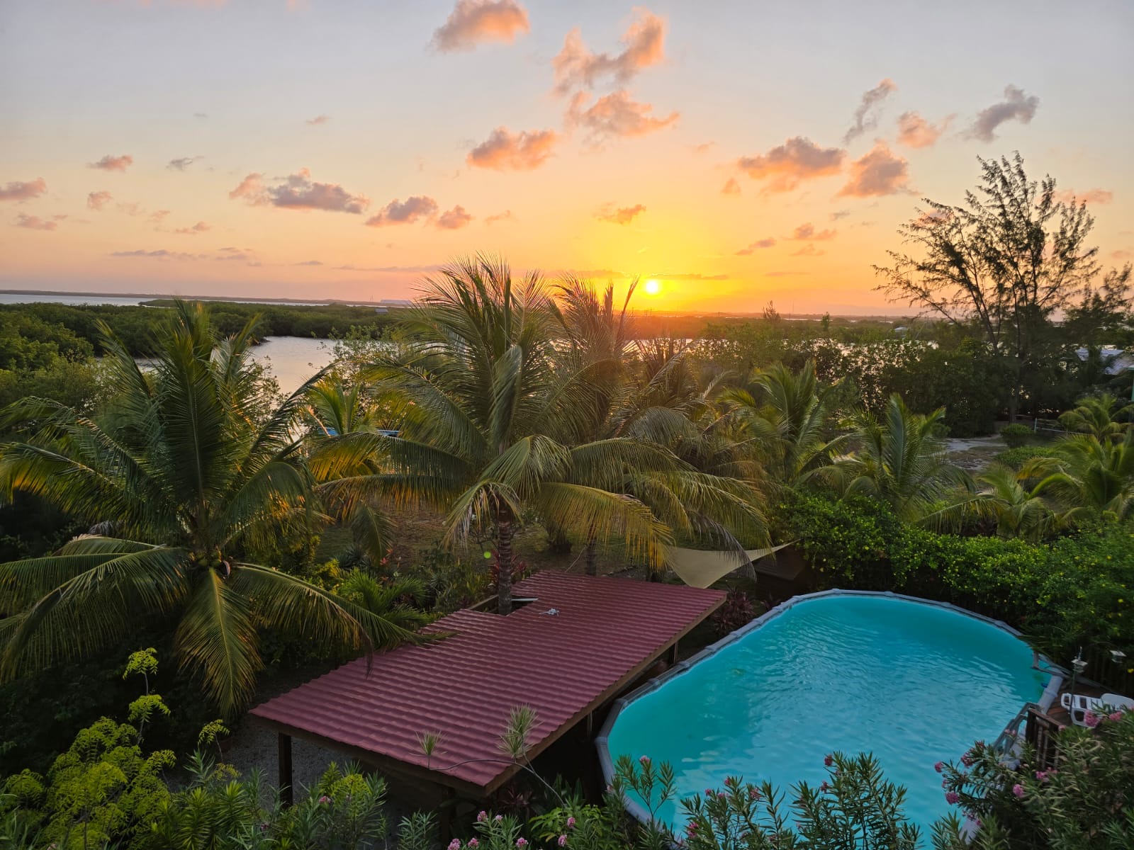 Scenic sunset over lush tropical landscape with pool at Las Brisas Island Community.