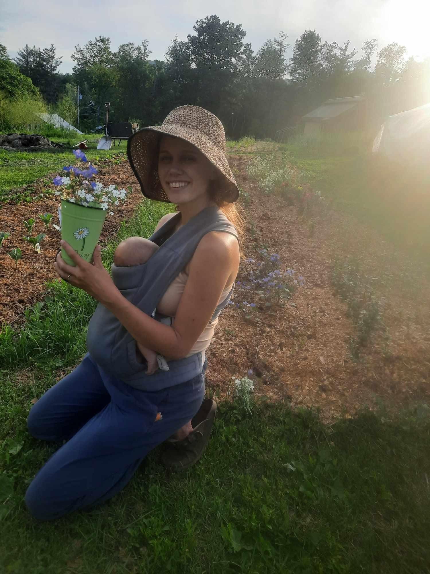 Woman with baby in a garden at Earthen Grove Ecovillage.