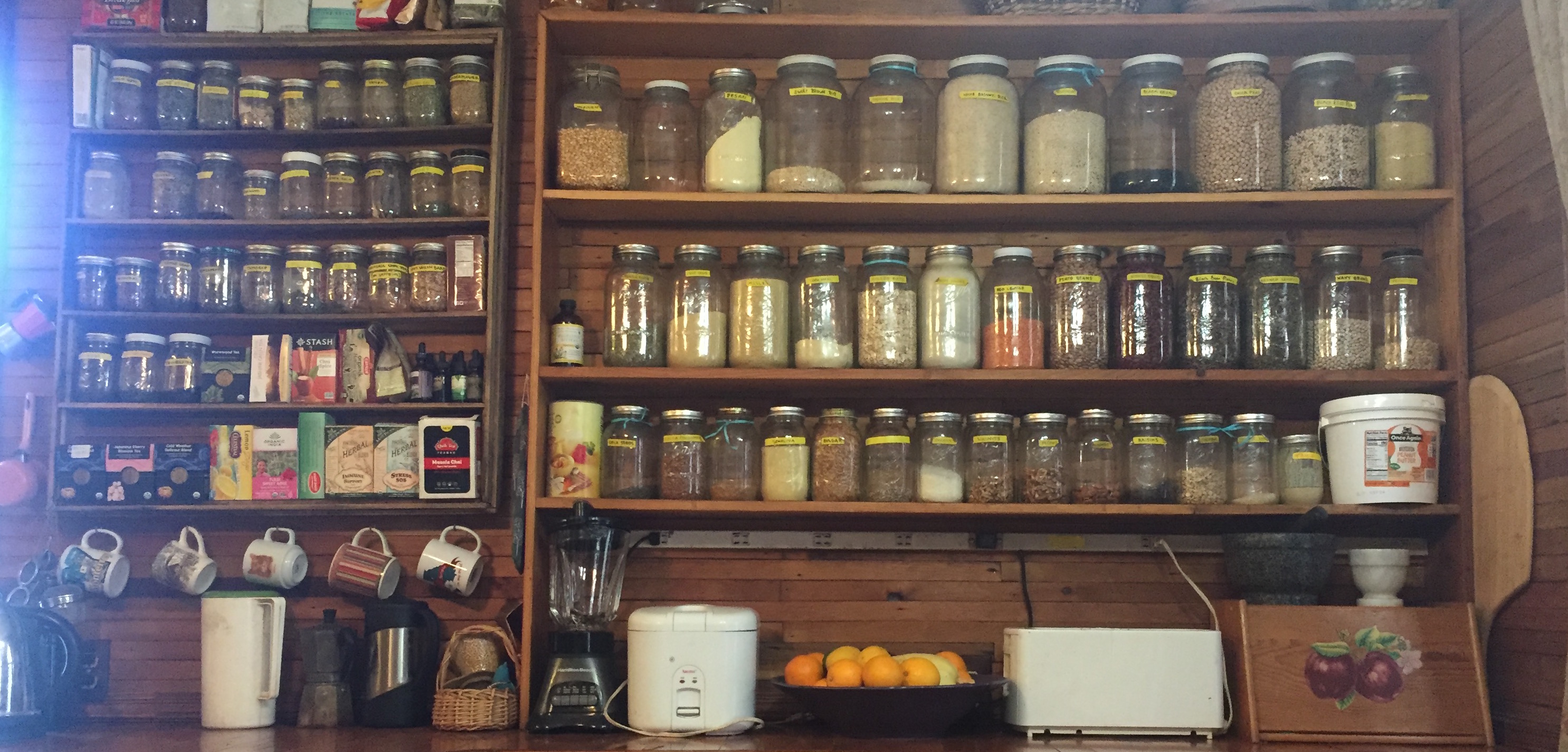A wooden shelf filled with jars of herbs and spices in a cozy kitchen setting.