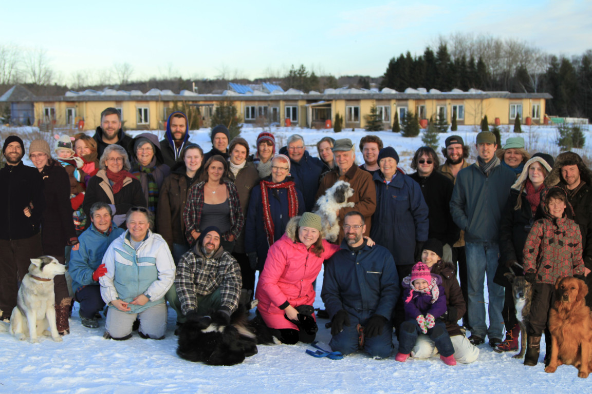 Group photo of residents and pets at Whole Village Ecovillage in winter.