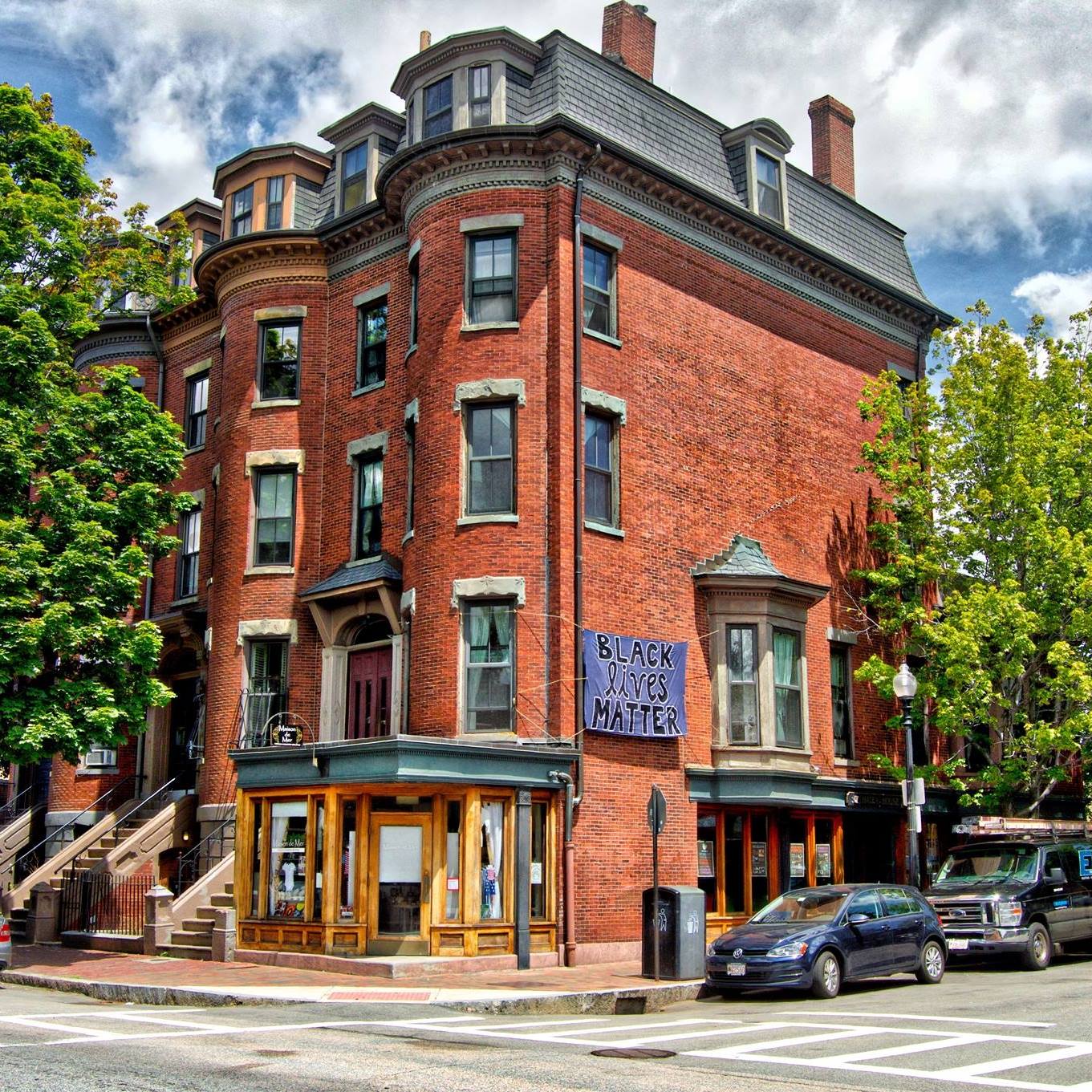 Historic brick building with Black Lives Matter banner and street view.