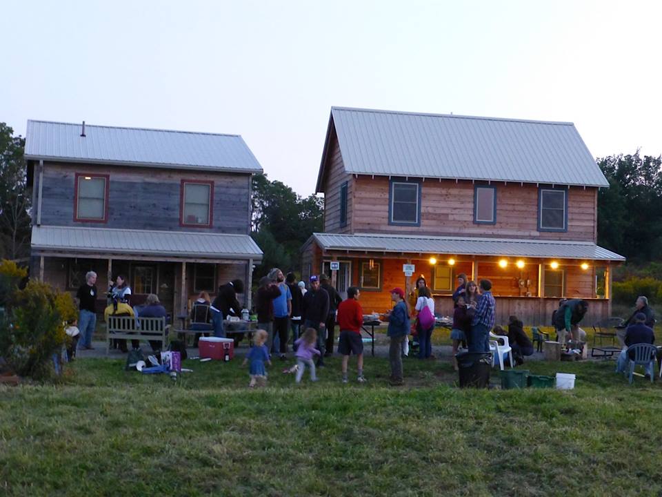 People gathering at White Hawk Ecovillage for community event and socializing.