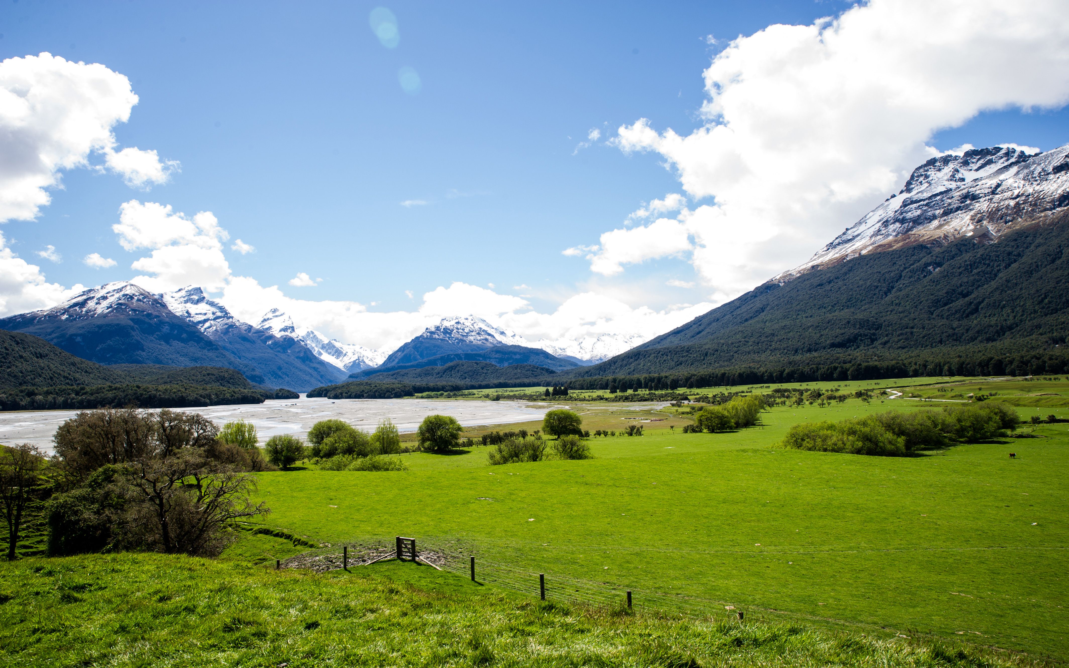 Beautiful mountain landscape with snow-capped peaks and green meadows.
