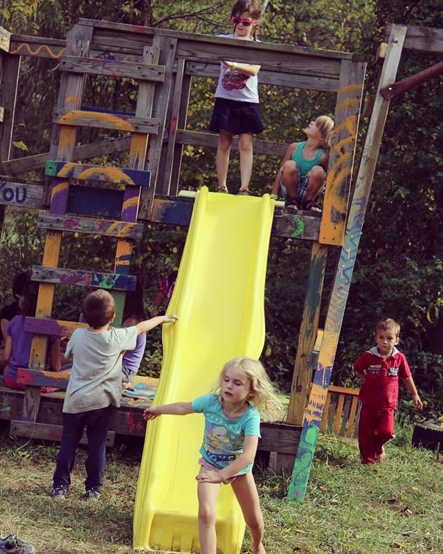 Kids enjoying outdoor play at Sage Valley Ecovillage playground.