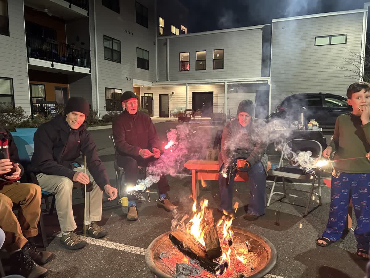 People gathered around a fire pit at night in Richmond Cohousing community.