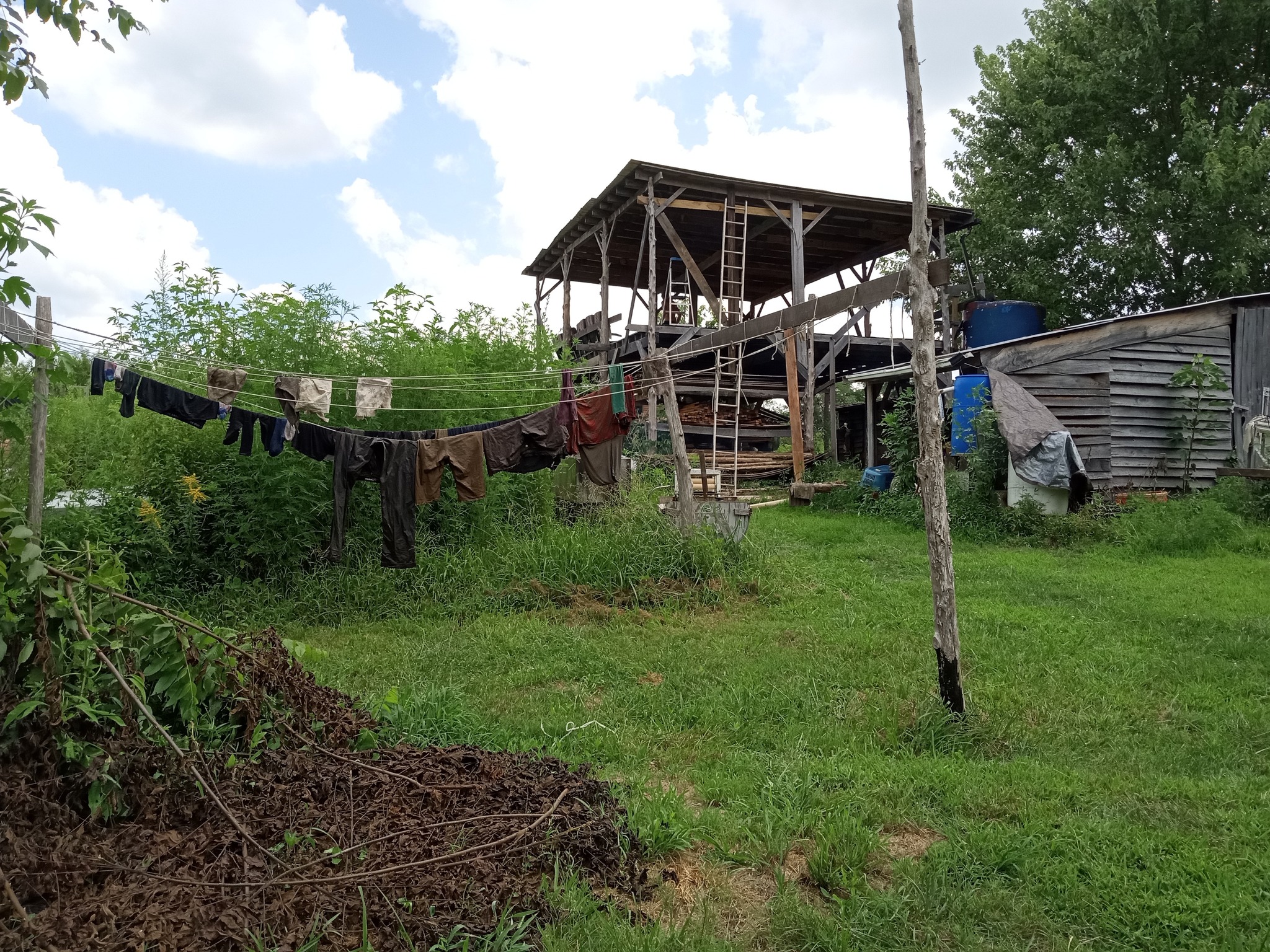 Rural community garden with clothesline and wooden structures in a green landscape.