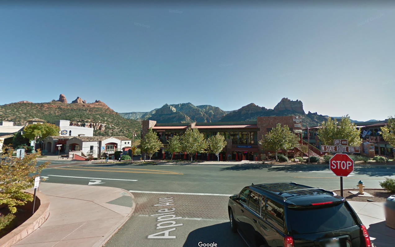 Community center with trees and mountains in the background, sunny day.