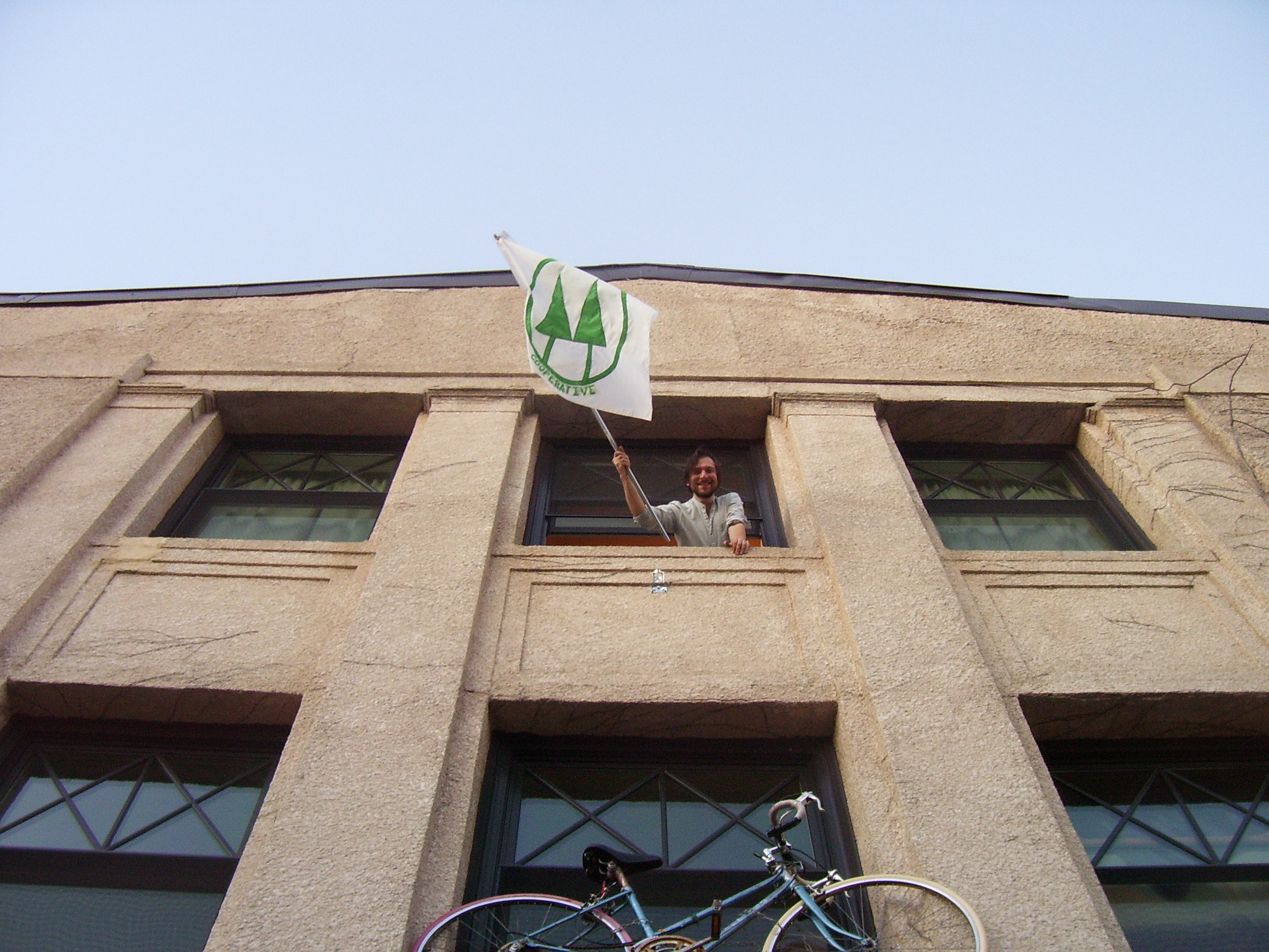 Person holding a flag from the Foundation for Intentional Community.