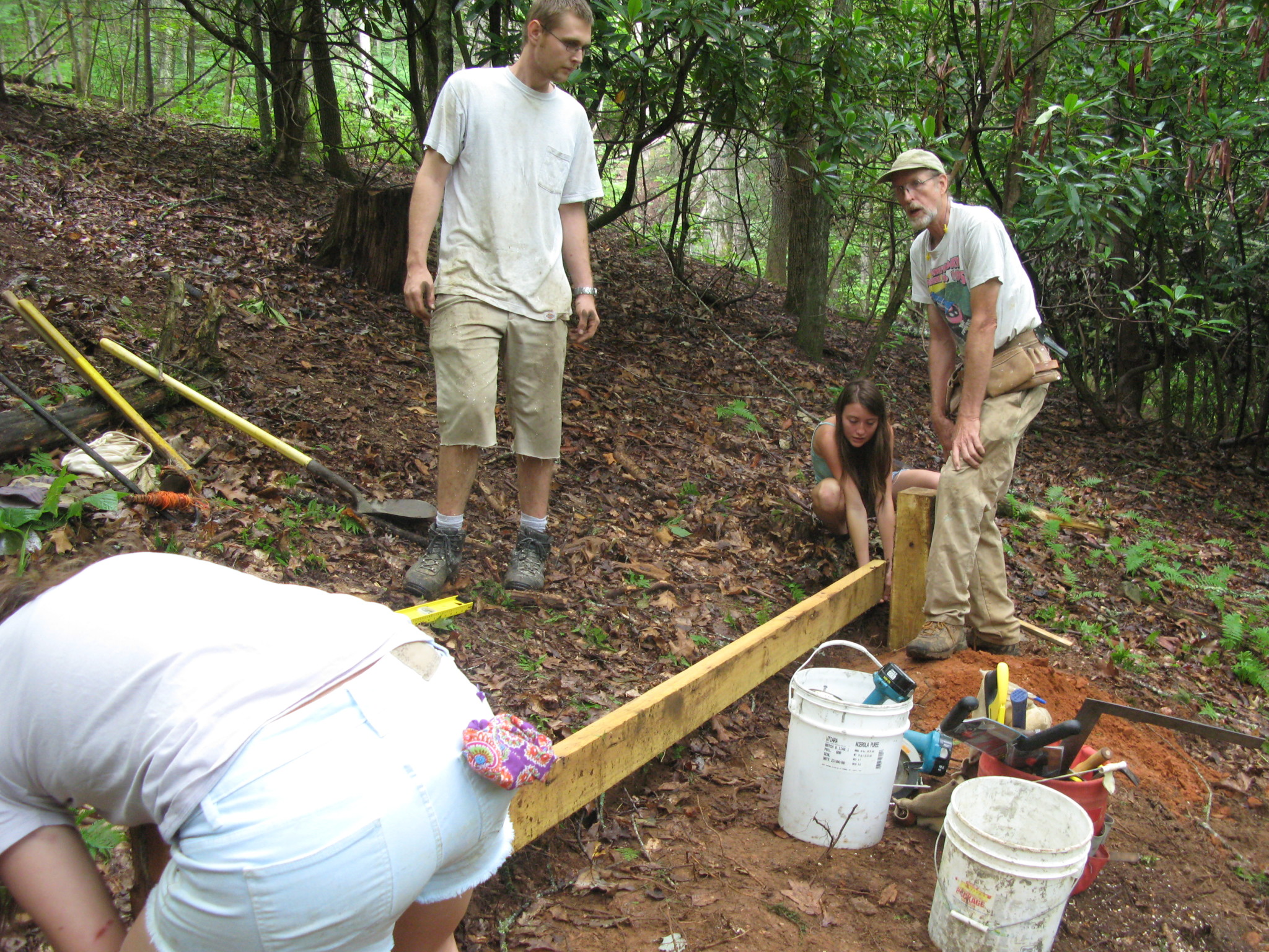 People working on a community project in a wooded area.