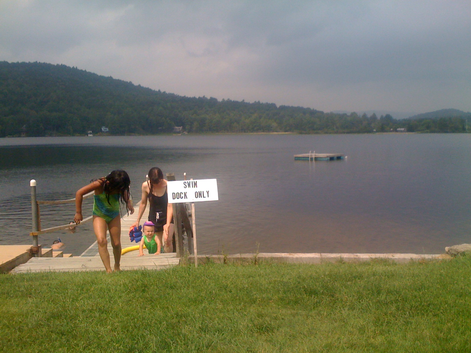 Family enjoying the community lake with children swimming and relaxing.