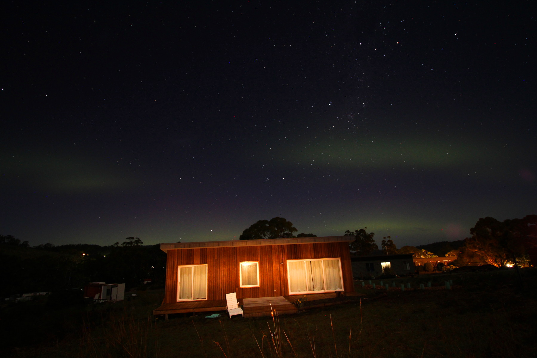 Night sky over Tasman Ecovillage with stars and northern lights.