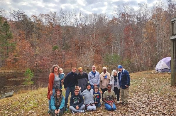 Group of diverse people outdoors in a forested area during fall.