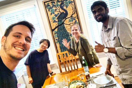 Group of diverse people smiling and enjoying a meal together indoors.