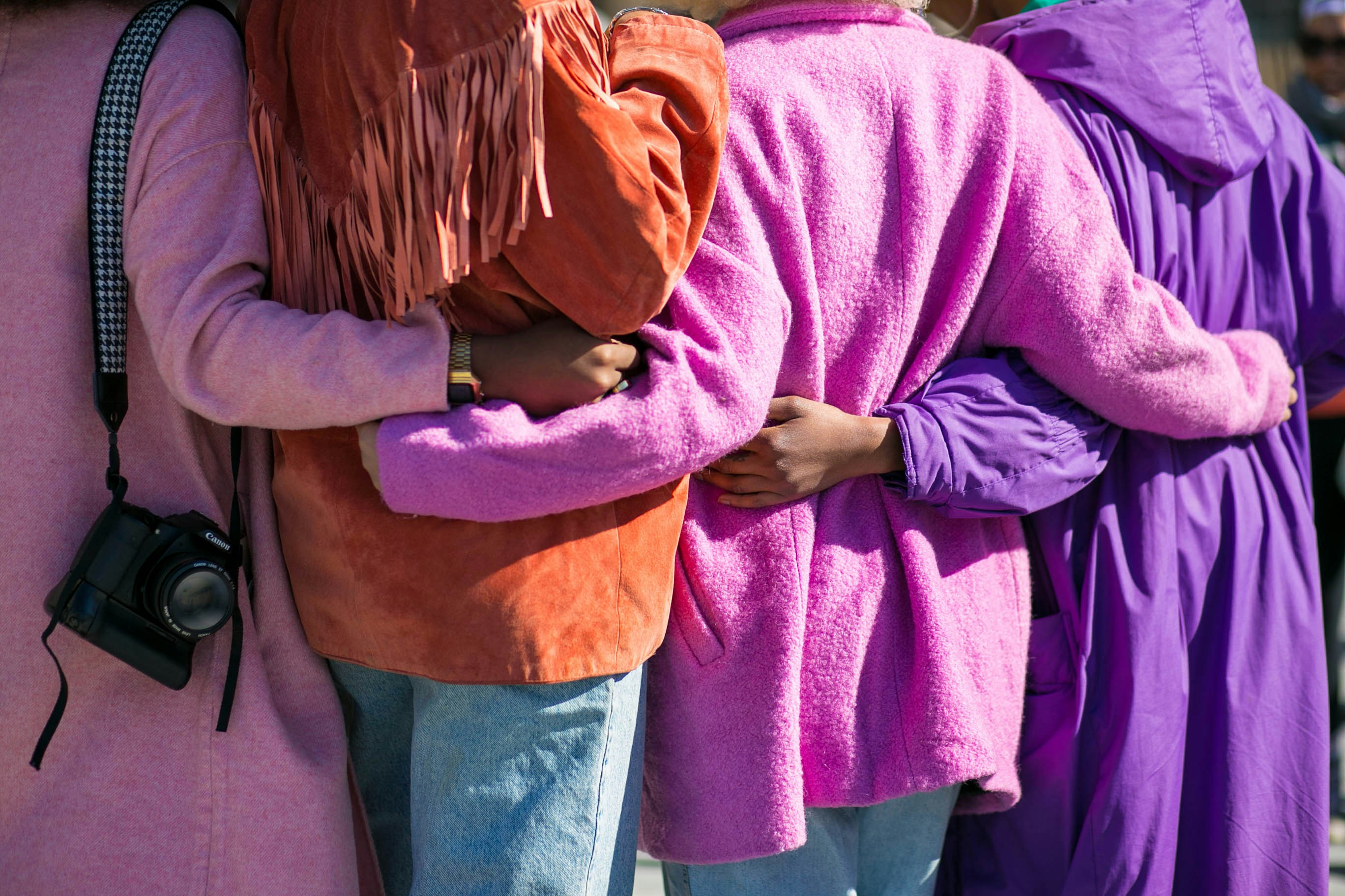 People embracing at Rainbow Family Community event, showing unity and diversity.