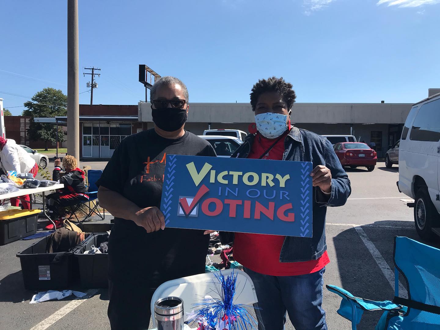 Two people holding a 'Victory in Our Voting' sign at Richmond Hill.