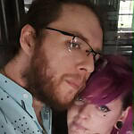 Two people at Foundation for Intentional Community event, close-up portrait.