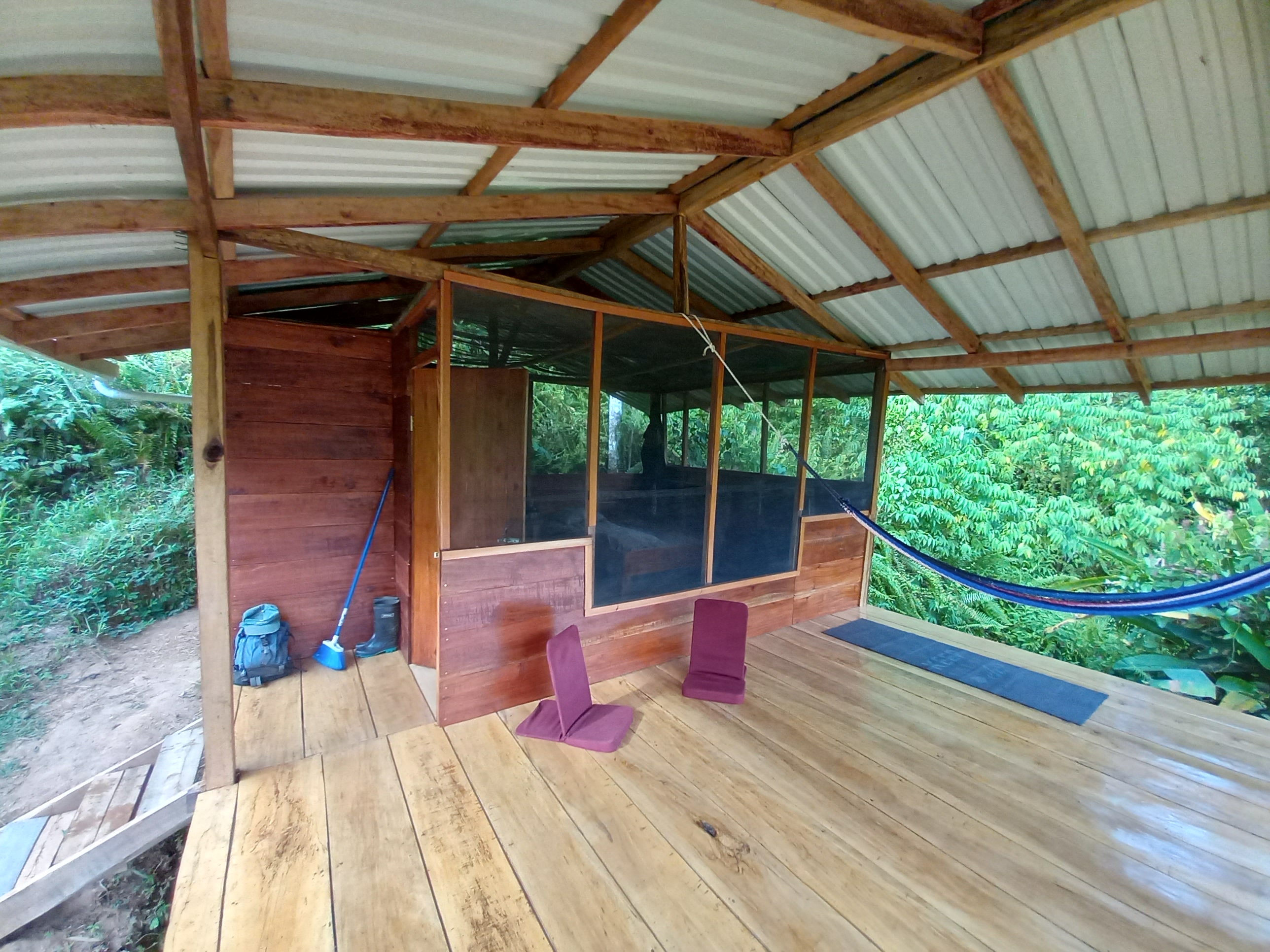 Wooden community cabin with screened porch and hammock at Valle Armonia.
