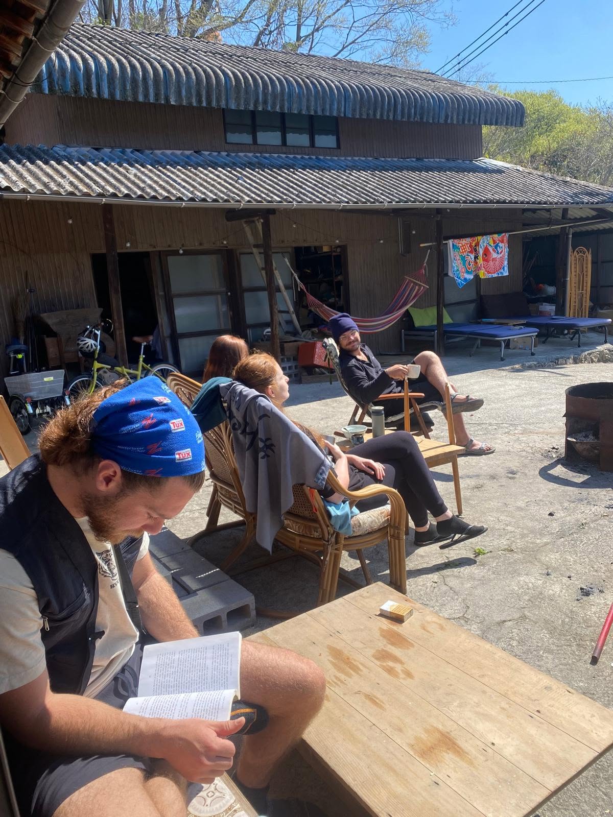 People relaxing outdoors at a community gathering in front of a house.