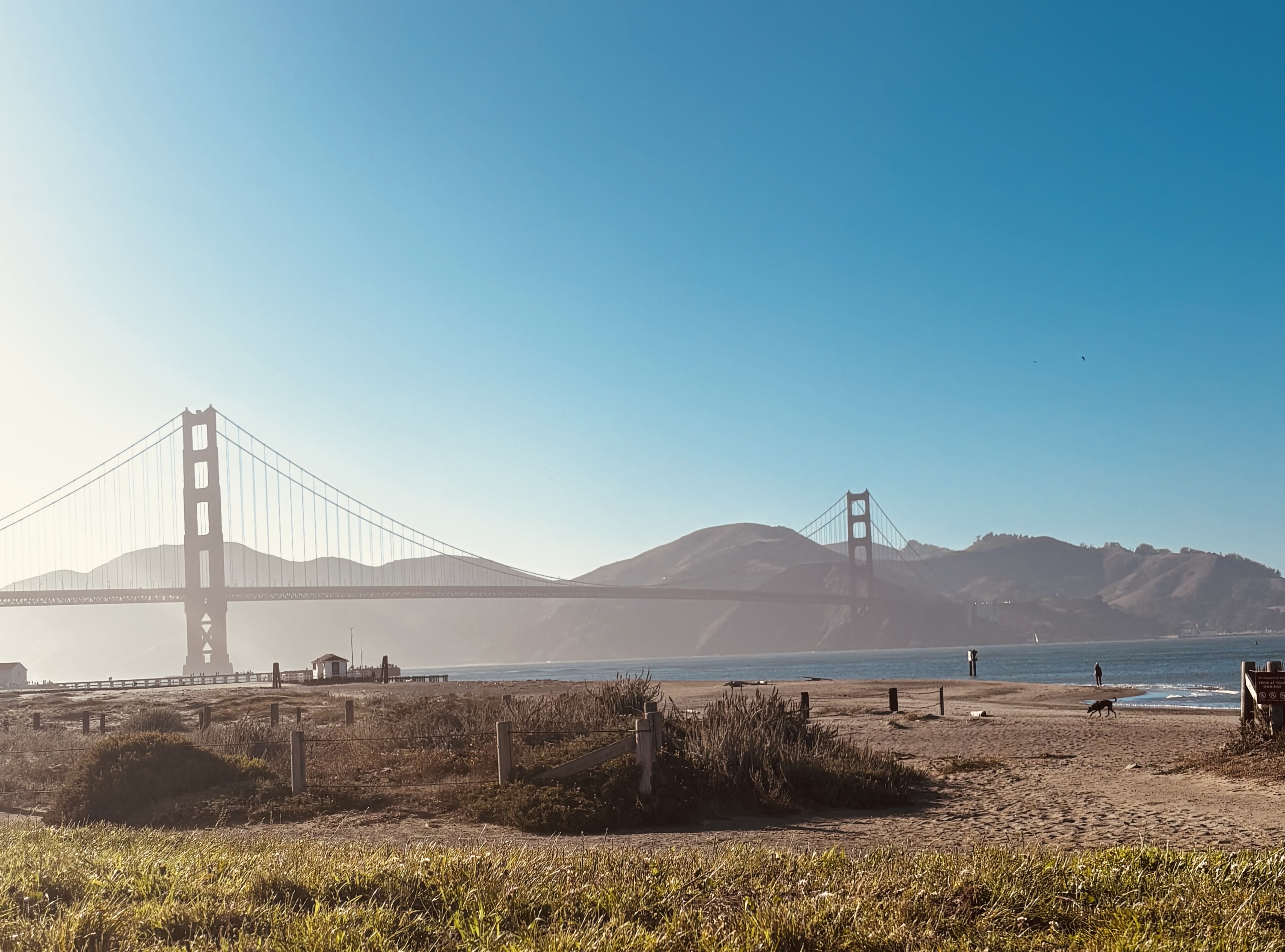 Scenic view of Golden Gate Bridge with clear blue sky and bay area landscape.
