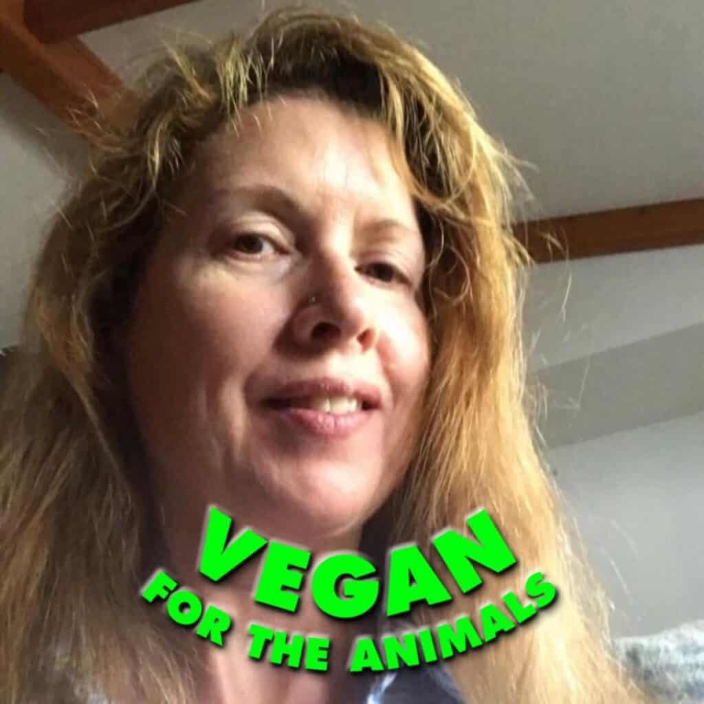 Close-up of a woman with long hair promoting veganism for animals.