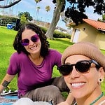 People enjoying outdoor community event with dog in a park setting.