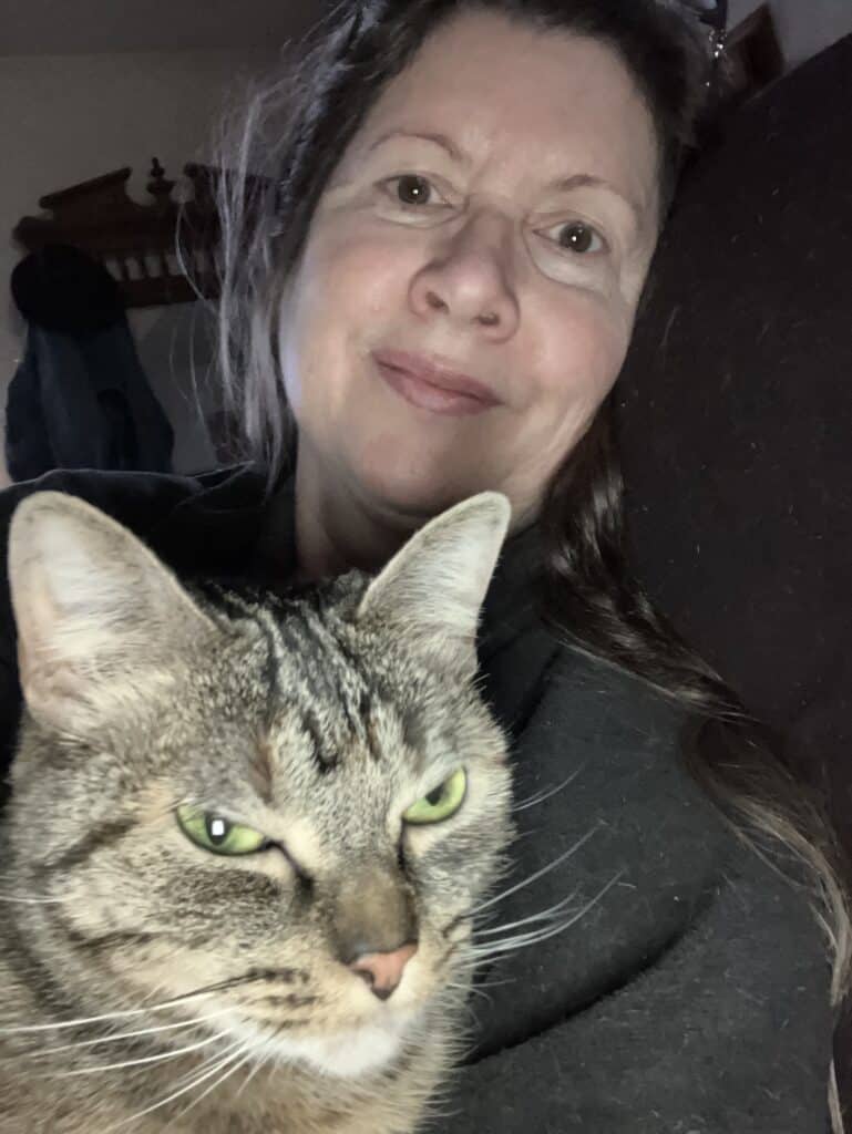Woman with a tabby cat, cozy indoor setting, Foundation for Intentional Community.
