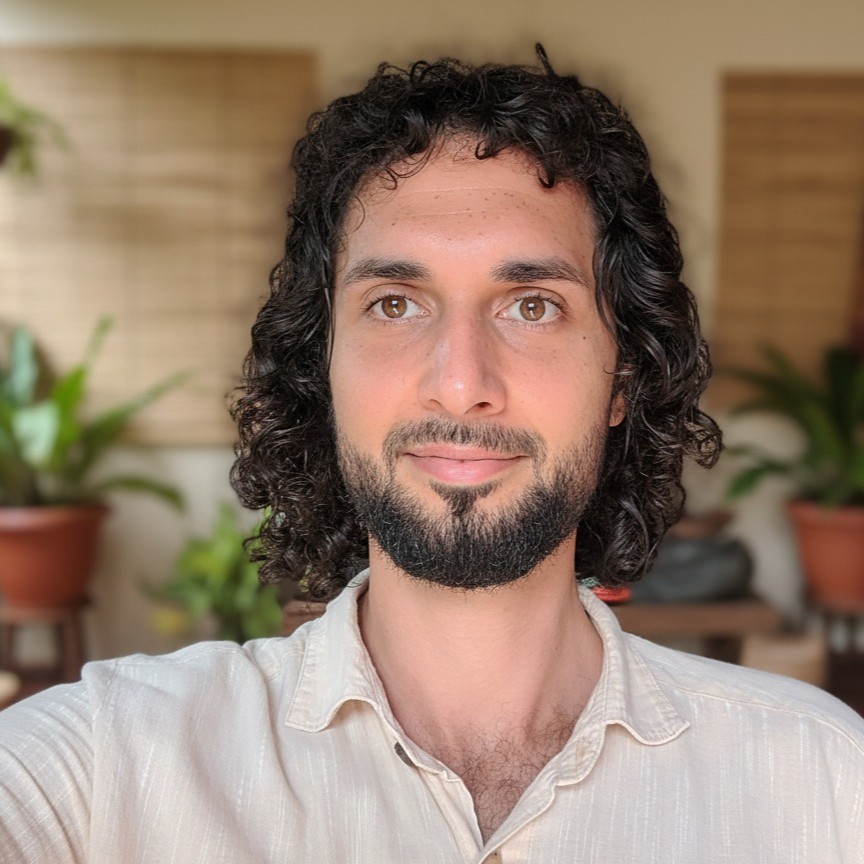 Portrait of a man with curly hair and beard at Foundation for Intentional Community.