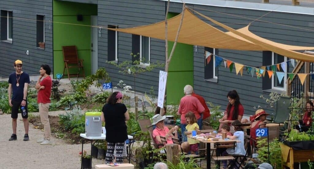 People gathering outdoors at a community event with tables and decorations.