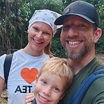 Happy family enjoying outdoor adventure in lush green forest setting.