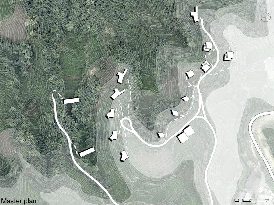Aerial view of community layout with buildings and roads on hilly terrain.