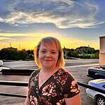 Woman smiling outdoors during sunset at Foundation for Intentional Community event.