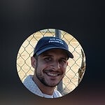 Smiling man wearing a blue cap with Foundation for Intentional Community logo.